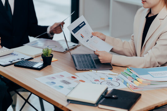 Business meeting about financial: a business meeting is taking place, with hands-on a document, charts, and a laptop. it indicates the importance of teamwork and financial concepts.