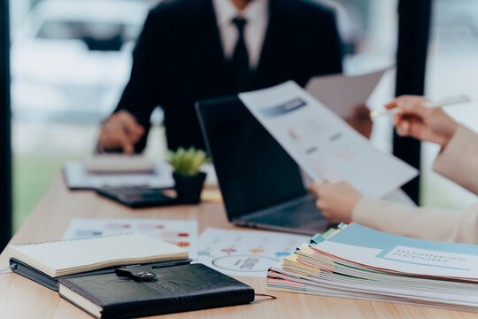 Strategic Financial Dialogue: In an office setting, professionals engage in an in-depth financial analysis. The scene captures the essence of strategic planning, review.