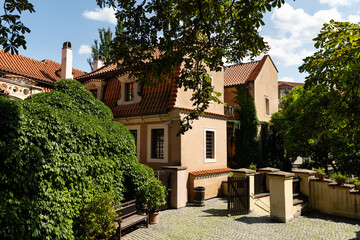 Prague, Czech Republic – August 6, 2025: Small courtyard at the entrance to the Gardens below Prague Castle in Prague, Czech Republic, with ivy, benches and tiled roofs on a summer day