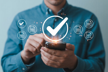 Man uses smartphone with checkmark and document icons for data validation verification and digital approval processes showcasing technology efficiency and modern business solutions