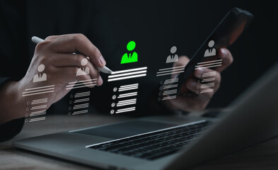 Human resources manager using digital recruitment system on laptop and smartphone, selecting candidate profiles with data analytics and modern HR technology interface.