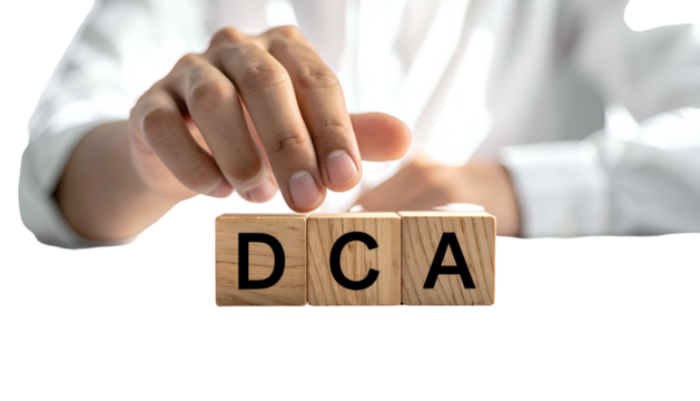 A person's hand placing a block labeled "A" beside "DCA" on three wooden blocks