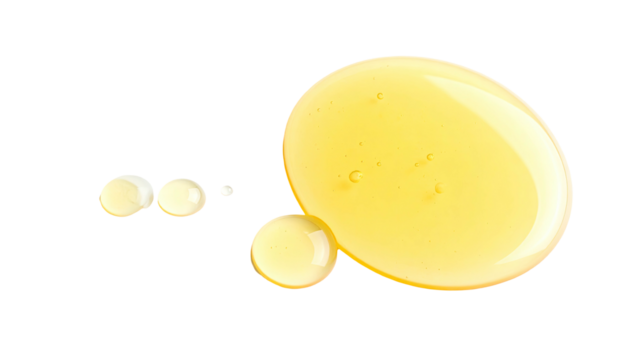 Droplets of golden liquid on a stark black background, showcasing texture and shape