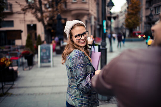Young adult woman smiling while shopping on city street