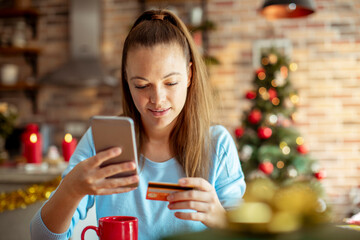 Young adult woman shopping online at home, focused