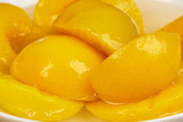 Half-cut peaches, canned preserve. Close-up photograph with copy space on a rustic background.