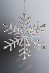 Decorative crystal snowflake ornament hanging from silver string  