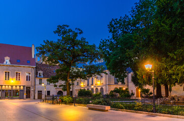 Place des Ducs de Bourgogne square in Dijon city historical centre with old typical houses medieval buildings, small park and green square, Dijon old town on twilight dusk evening view, France