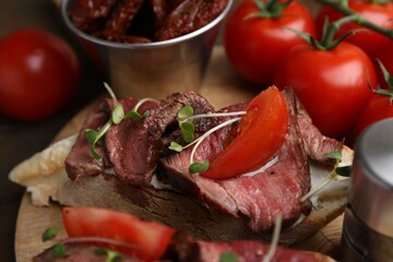Delicious bruschetta with roast beef served on wooden table, closeup