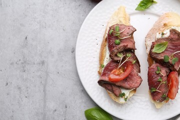 Delicious bruschettas with roast beef served on light table, top view. Space for text