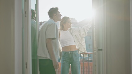 Obraz premium Romantic people enjoying cityscape on balcony. Smiling sweethearts talk on date