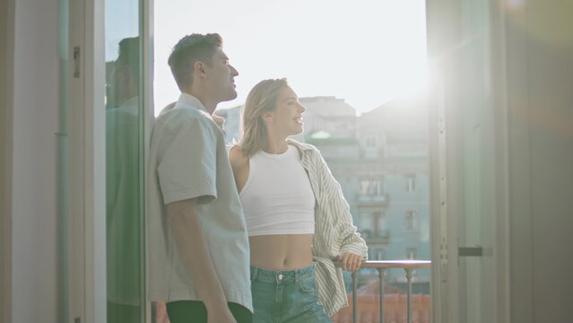 Relaxed lovers standing balcony enjoying cityscape on date. Casual couple talk