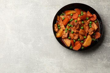 Delicious cooked stew on grey table, top view. Space for text