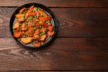 Delicious cooked stew on wooden table, top view. Space for text