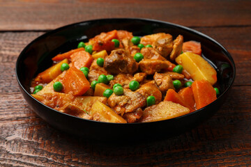 Delicious cooked stew on wooden table, closeup