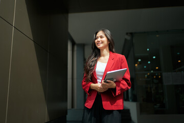 Asian businesswoman holding tablet smiling looking forward