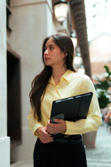Fototapeta premium Asian working woman holding tablet walking in city