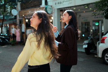 Women business colleagues pointing walking urban street