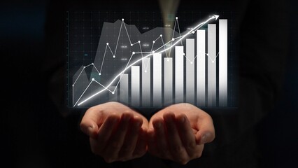 A pair of hands supports a digital graph displaying financial growth through bar charts and a trend line, symbolizing success and innovation in business. Copula