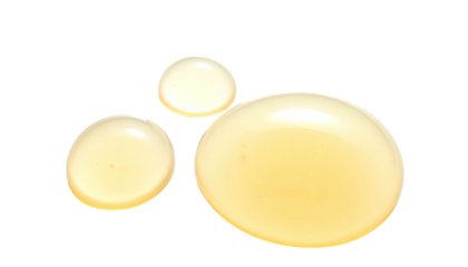 Three glistening, yellow droplets of liquid on a stark black background