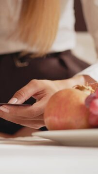 A person's hand holding a credit card and a pair of scissors, possibly cutting it. Vertical video.
