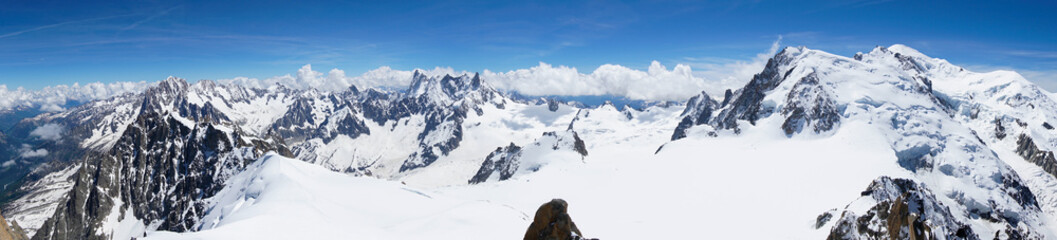 A view of a ridge of jagged, high, snow-covered mountains in the French Alps Photo taken from the Aiguille du Midi mountain Chamonix large snow cover with footprints is visible