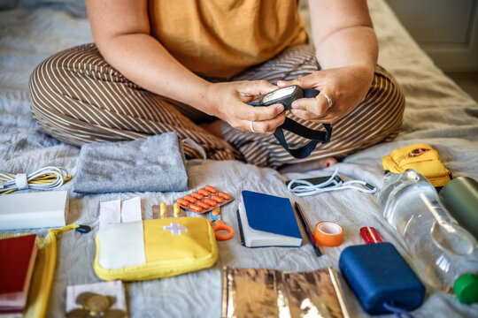 Equipment check - woman testing headlamp while assembling emergency go-bag