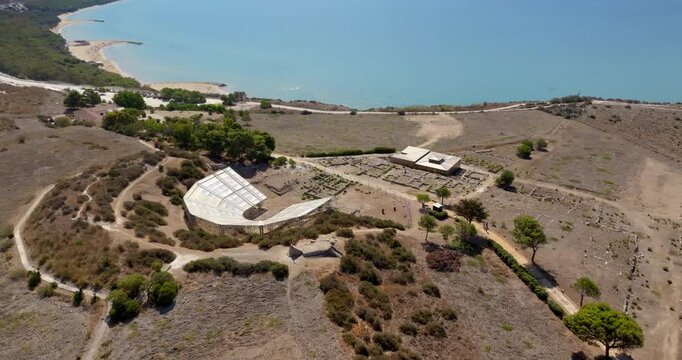 Aerial view of the theater of Eraclea Minoa. It's a ancient Greek theater located in the archaeological site of ​​Cattolica Eraclea, in province of Agrigento, Sicily, Italy. In background is azure sea