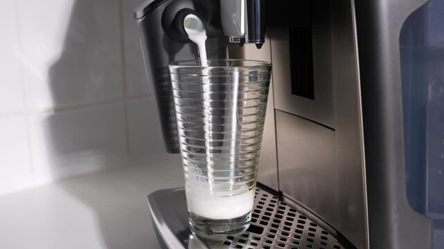 Espresso cascades into a foamy milk glass, creating soft marbled patterns. Cafe vibes at home.