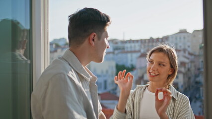 Obraz premium Happy lovers talking balcony in evening sunlight. Closeup cheerful girl hug man