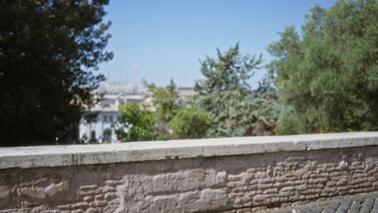 Stone wall and cobblestone foreground with defocused bokeh view of distant architecture overlooking park; backplate copyspace backdrop calm.