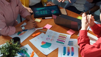 Top down view of multicultural business group putting hand together to celebrate increasing sales...