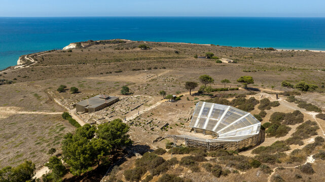 Aerial view of the theater of Eraclea Minoa. It's a ancient Greek theater located in the archaeological site of ​​Cattolica Eraclea, in province of Agrigento, Sicily, Italy. In background is azure sea