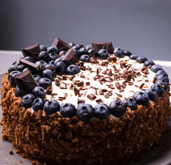 delicious chocolate cake with candles and blueberries for a holiday or birthday