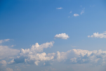 A beautiful and serene blue sky adorned with soft and fluffy white clouds drifting by