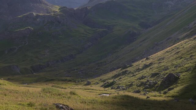 High Contrast Alpine Valley Entrance Under Dramatic Sidelight and Cloudy Sky