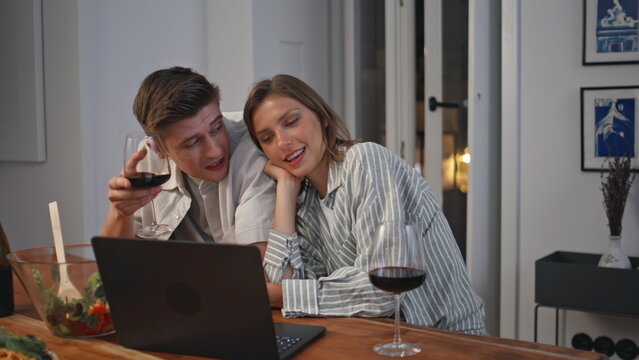 Man woman relaxing home with wine closeup. Loving couple watching laptop movie - Powered by Adobe