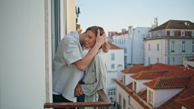 Loving people hugging rooftops view. Affectionate boyfriend embracing on balcony