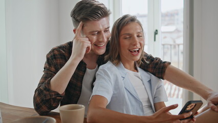 Relaxed sweethearts using smartphone in serene morning. Closeup loving couple