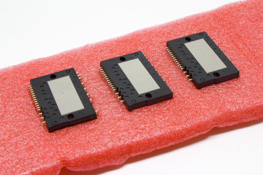 Trio of rectangular IPM power modules neatly aligned on antistatic foam, angled to emphasize the connector rows