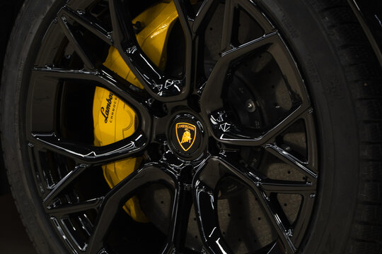 Black cast disc and carbon ceramic brake disc, yellow caliper on a Lamborghini Urus car. Lamborghini Urus ventilated brake disc with a yellow caliper and brake pads. CCB. 