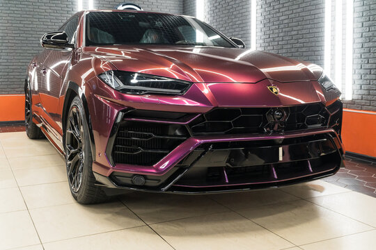 The Lamborghini Urus in violet PPF is a high performance luxury SUV manufactured by Italian automobile manufacturer. Yellow color Urus in the tuning studio. Wrap car. 