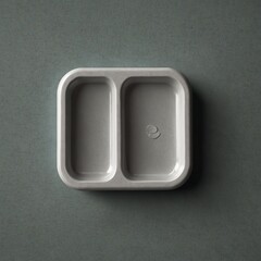 Empty two-compartment food tray in gray on dark background