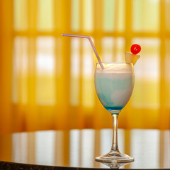 Tropical cocktail with cherry and pineapple garnish on a table