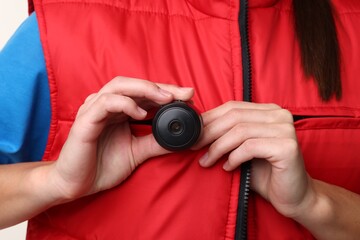 Courier with hidden spy camera on white background, closeup