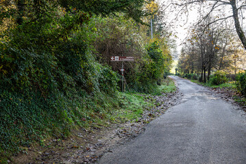 Italian countryside road with hiking trail sign