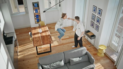 Happy spouses buying house together. Top view excited man giving apartment key