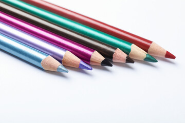 Colorful eye pencils on white background, closeup