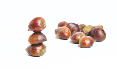Chestnuts stacked on a white background.	