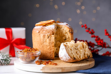 Christmas food. Delicious Panettone cake and festive decor on white table against background with blurred lights, closeup